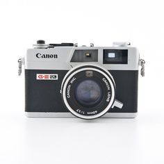 an old camera with a lens attached to it on a white surface, taken from the front