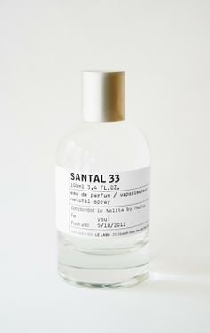 a bottle of santal 33 cologne sitting on top of a table