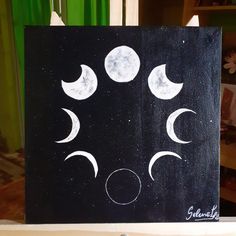 a black canvas with the moon phases painted on it