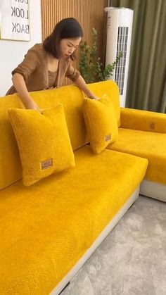 a woman sitting on top of a yellow couch