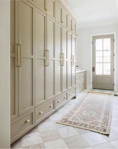 a large white rug in the middle of a room with beige cabinets and an area rug on the floor