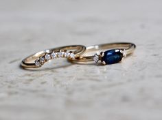 "Loving this beautiful Blue Sapphire. This ring is perfect as a gift, something blue, or as an engagement ring for the girl that wants something different. - 6x4mm Blue Sapphire center stone - 1.3mm side diamonds (.02 Ct total) - 1.3mm round band - Available in 14K yellow, white or rose gold Pairs perfectly with our seven diamond \"Crown\" wedding band! Click here: https://www.etsy.com/listing/555115894/14k-gold-diamond-curved-wedding-band?ref=shop_home_active_1 Processing Times - Current proces Blue Oval Diamond Ring For Gift, Blue Oval Stackable Rings, Diamond Ring Oval, Engagement Ring Three Stone, Oval Stone Ring, Blue Sapphire Diamond Ring, Ring Three Stone, Diamond Crown, Crown Wedding