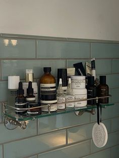 a shelf filled with lots of different types of skin care products on top of a tiled wall