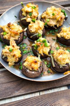 stuffed mushrooms with cheese and green onions on a plate