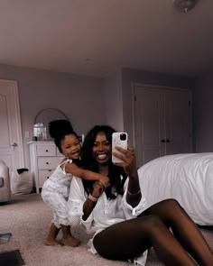 two women sitting on the floor taking a selfie