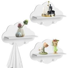 two white cloud shaped shelves with decorative items on them, one holding a candle and the other holding a potted plant