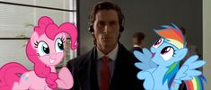 a man in a suit and tie standing next to two pinkie ponies with rainbows on them