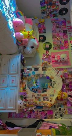 a room filled with lots of toys and clutter on the walls, including a mirror