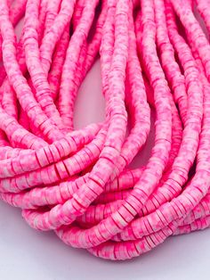 pink and white round beads on a white surface