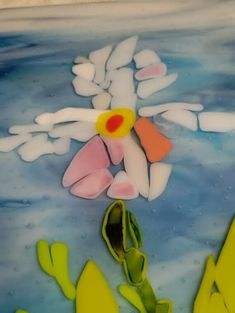 an artistic glass painting with flowers and leaves in the water, surrounded by other pieces of art