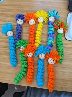 crocheted carrots with faces on them sitting on a table