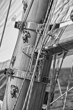 black and white photograph of the masts of a sailboat with ropes on it