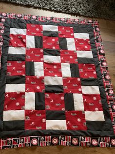 a red and black quilt is laying on the floor