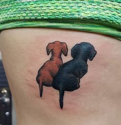 two dogs sitting on top of each other in the shape of a woman's thigh