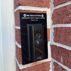 a black speaker mounted to the side of a brick wall