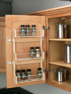 the cabinet door is open to show spices and spice racks in it's drawers