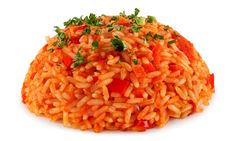 a pile of rice with tomatoes and parsley on top, sitting on a white surface