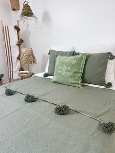 a bed with green and white pillows on top of it