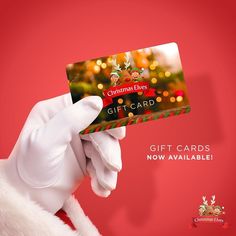 a person in white gloves holding up a christmas gift card