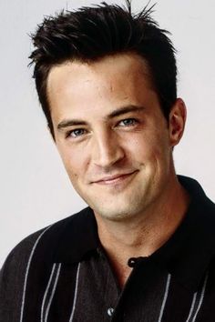 a close up of a person wearing a black shirt and smiling with a white background