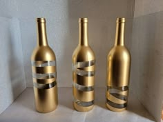 three gold wine bottles sitting next to each other