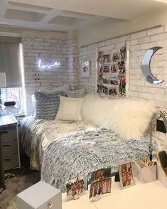 a white brick wall in a bedroom with a bed, desk and computer on it