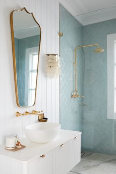 a white sink sitting under a bathroom mirror