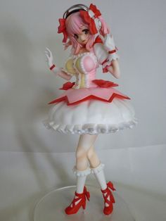 a figurine that is sitting on top of a glass plate with red shoes