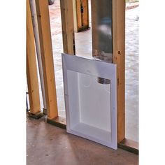 an open white box sitting on top of a floor next to a wooden wall and door