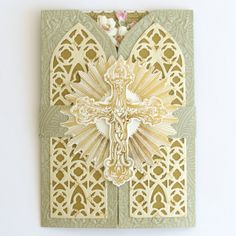 an intricately designed card with a cross on the front and side, in gold foil