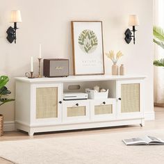 a white entertainment center with wicker doors and drawers in a living room next to a potted plant