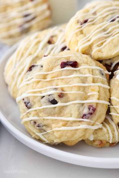 cookies with white icing and cranberries on a plate