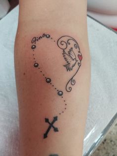 a tattoo on the leg of a woman with two crosses and an angel above her head