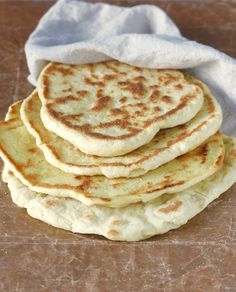 a stack of flat bread on top of a wooden table