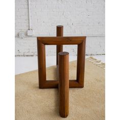 two wooden tables sitting on top of a rug next to a white brick wall and floor