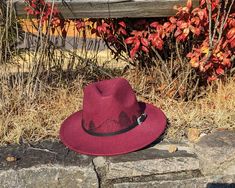 This burgundy small brim fedora would make a gorgeous addition to any nature lover's wardrobe. Along the entire crown of the hat I hand burnt and shaded textured mountains and pine trees. I also added handburnt stitch marks on several places along the brim of the hat. All my designs are original and completely freehanded. For a finishing touch the hat is adorned with a black faux leather hat belt with a ornate siver buckle. Hat Materials: Polyester Hat has an adjustable tie band inside Head Circumference: 56-58 cm Hat Brim: roughly 2.75 inches *Disclaimer* Colors may vary slightly from screen to screen hand burned mens fedora would make a great addition to any nature lover's wardrobe. Burgundy Brimmed Fedora For Fall, Burgundy Fedora Hat For Fall, Burgundy Curved Brim Hat For Fall, Burgundy Short Brim Hat For Fall, Adjustable Burgundy Hat For Fall, Adjustable Burgundy Fall Hat, Adjustable Burgundy Felt Hat With Curved Brim, Adjustable Burgundy Felt Hat With Flat Brim, Adjustable Burgundy Flat Brim Hat