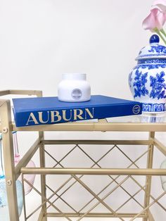 a blue and white vase sitting on top of a table next to a blue and white book