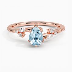 a rose gold ring with an aqua blue topazte and diamonds