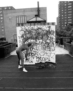 a person standing in front of a wall with graffiti on it