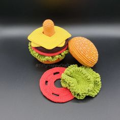 three crocheted hamburgers with hats on them