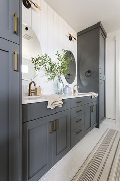 a bathroom with gray cabinets and gold handles