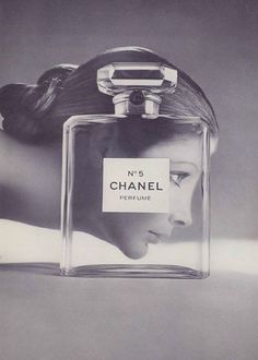 a black and white photo of a woman's face in a chanel perfume bottle