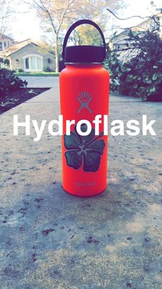 an orange hydro flask with a butterfly on the side and words hydro flask above it