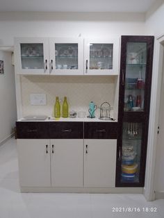 a kitchen with white cabinets and black counter tops, glass doors on the back wall