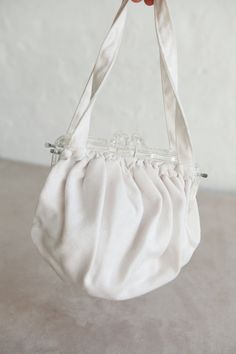 "Vintage Soft Linen Hand Bag with a Clear Chunky Lucite Clasp and Linen Handles.  Can easily fit a small wallet/coin purse, lipsticks, and other small make up items. Perfect for a Bride, Bridesmaid or even a Flower Girl. Color: White / Ivory Good vintage condition. Some signs of wear consistent with age. Age: Vintage ~1970s Dimensions:  ~7.5\" long x 8\" wide x 4\" deep 7\" Handle length 6.5\" Lucite Clasp length Tags: Bride, Bridesmaid, Flower girl, Purse, Handbag," Vintage White Pouch Shoulder Bag, Cream Evening Bag With Removable Pouch, Cream Coin Purse For Daily Use, Vintage White Pouch Bag, Chic White Coin Purse For Daily Use, Beige Clutch Coin Purse For Daily Use, Elegant Beige Coin Purse For Daily Use, Vintage White Clutch For Everyday Use, Cream Rectangular Coin Purse For Everyday Use