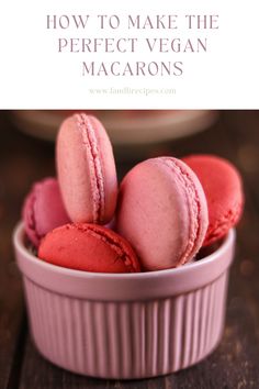 pink macaroons in a white bowl on a wooden table