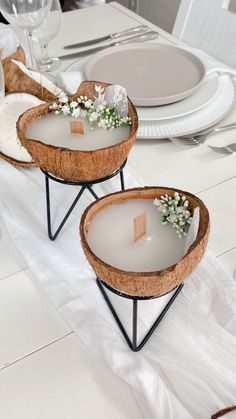 two trays with flowers on them sitting on a dining room table set for dinner