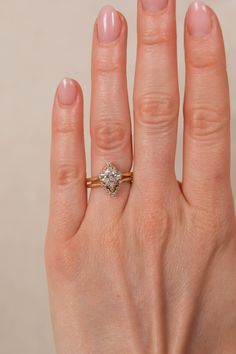 a woman's hand with a diamond ring on top of her finger, showing the middle finger