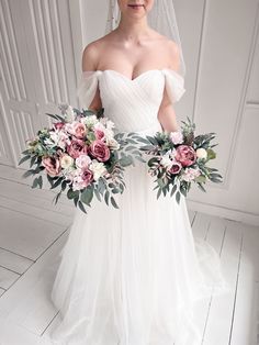 a woman in a wedding dress holding two bouquets