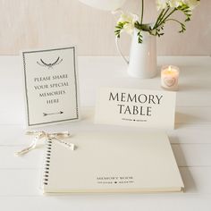 a table with a book, vase and flowers on it next to a memory card